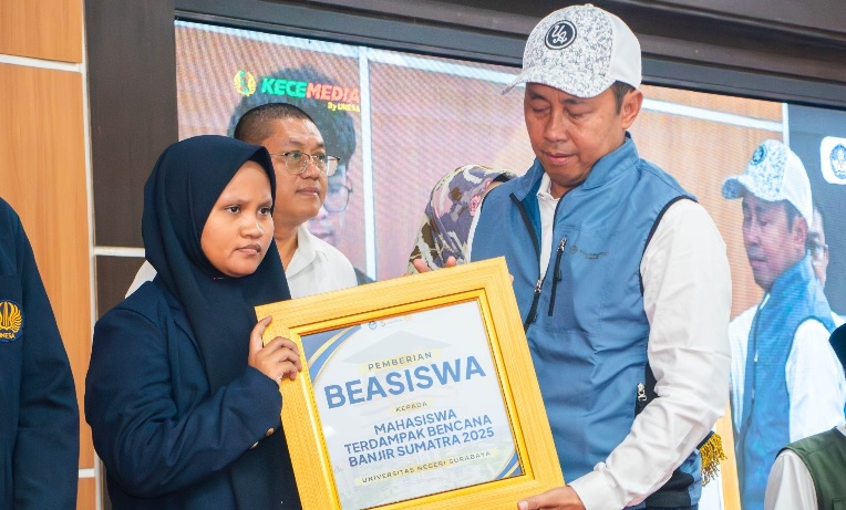 Wakil Rektor IV Unesa, Dwi Cahyo Kartiko menyerahkan beasiswa kepada mahasiswa asal Sumatera yang terdampak banjir, dalam acara doa bersama dan penggalangan dana untuk korban banjir, di Auditorium Rektorat, Kampus II Lidah Wetan.